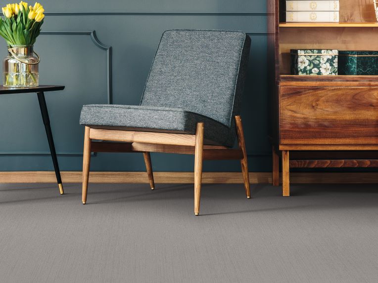 grey carpets in a modern living room with accent wall and bookcase