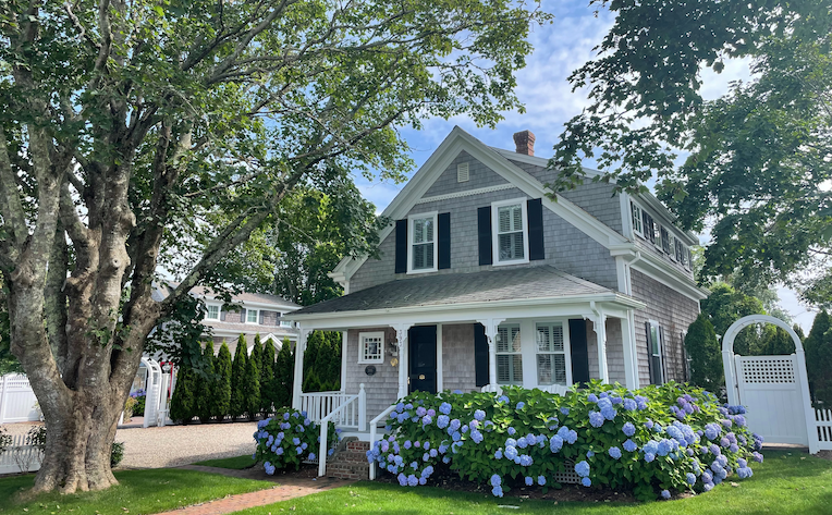 Example of Increased home value using curb appeal including a well landscaped lawn, flowers, and entryway